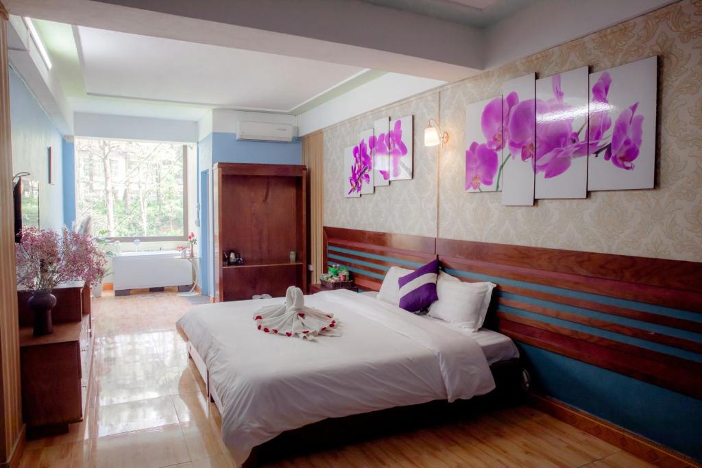 a bedroom with a large white bed with purple accents at Sapa Friendly Inn Hotel in Sa Pa