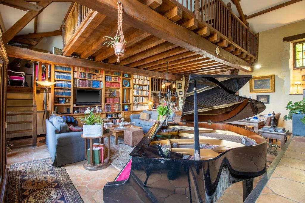 a large living room with a large piano in it at Gîtes et chambres croix du sud in Saint-Amand-de-Vergt
