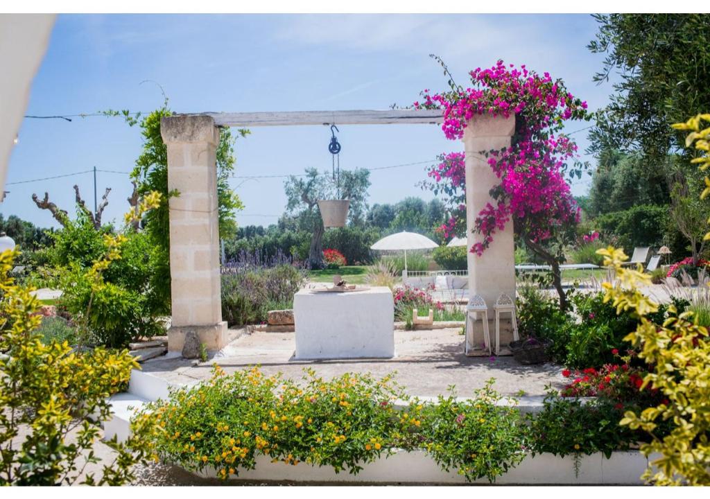 een boog met bloemen in een tuin bij Masseria Verbena suites in Macchia di Monte