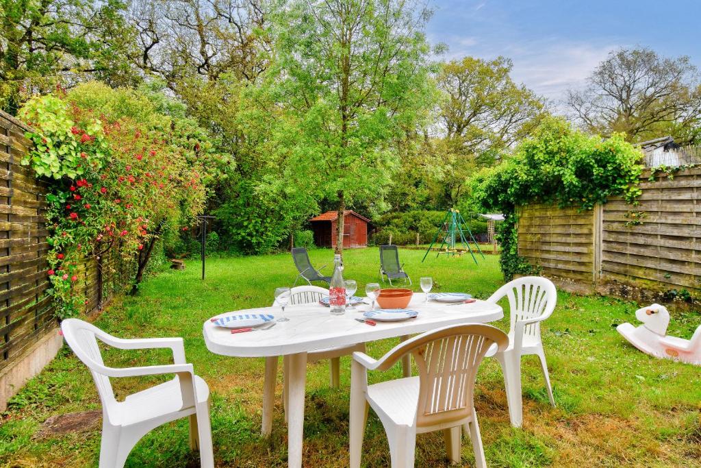 uma mesa branca e cadeiras num quintal em Sejour calme dans une maison avec jardin em Saint-Maixent-sur-Vie