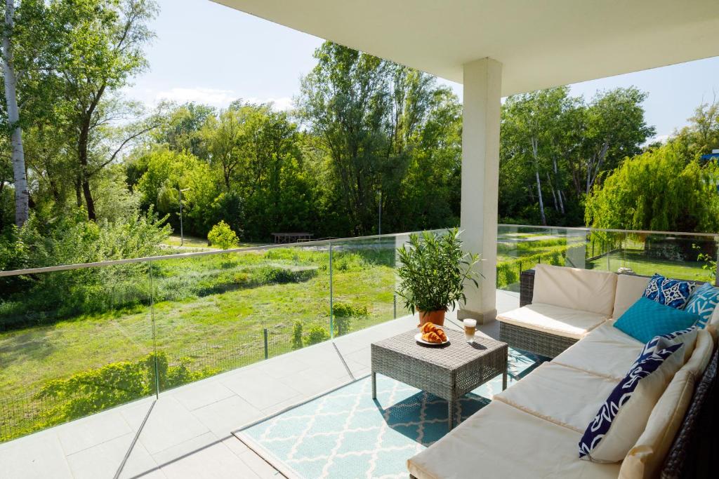 a screened in porch with a couch and a table at Blue4 Apartment in Balatonfůzfő