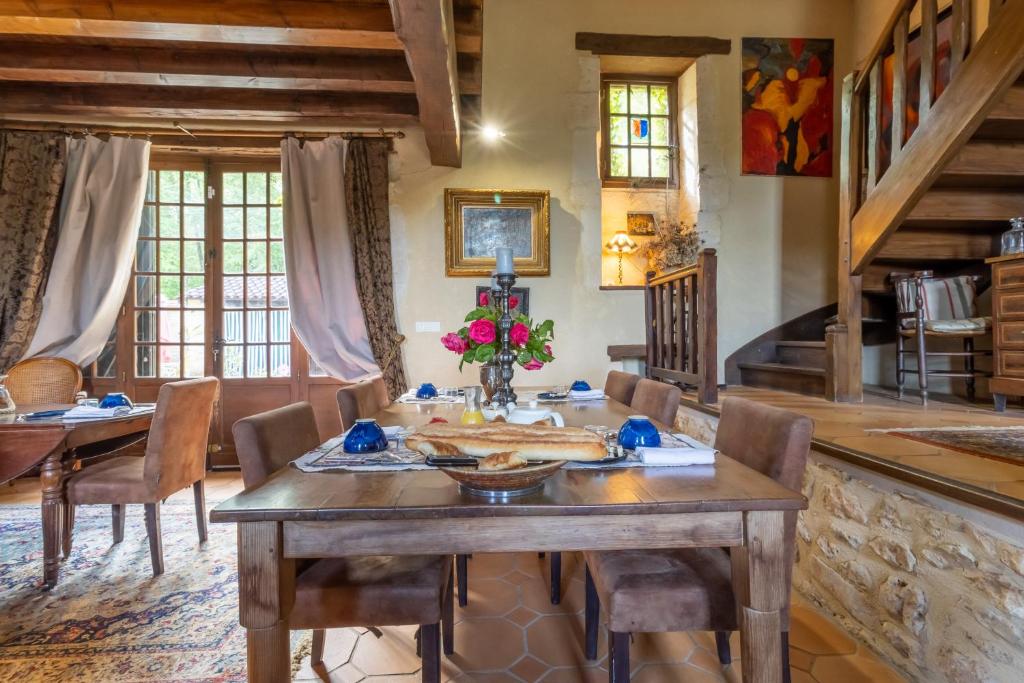 a dining room with a wooden table and chairs at Gîtes et chambres croix du sud in Saint-Amand-de-Vergt