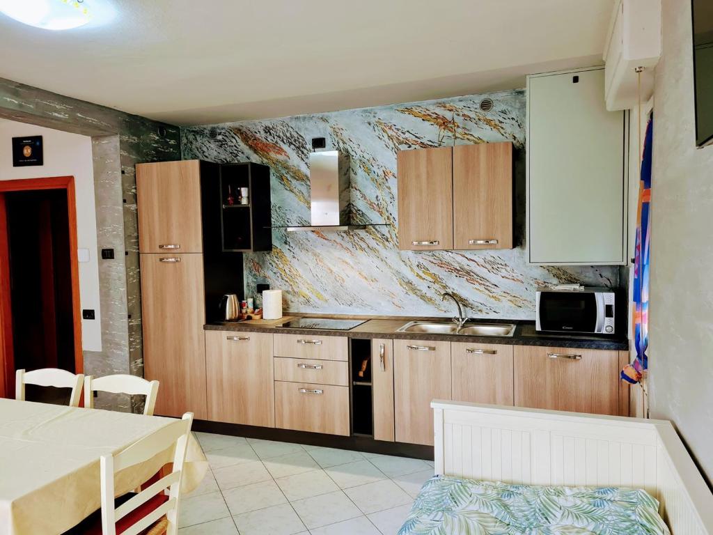 una cucina con armadi in legno e piano di lavoro di Kidonia - Iseo Lake Apartmens a Sale Marasino