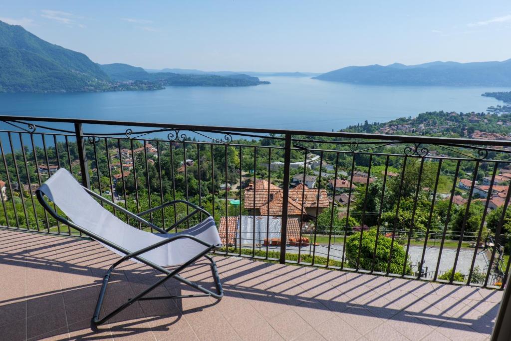 une chaise blanche assise sur un balcon donnant sur le lac dans l'établissement Casetta di Rosetta, à Arizzano