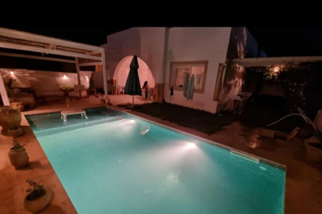 a large swimming pool in a living room at night at Dar Douja à Chaffar / Ton chez-toi près de la plage in Nakta