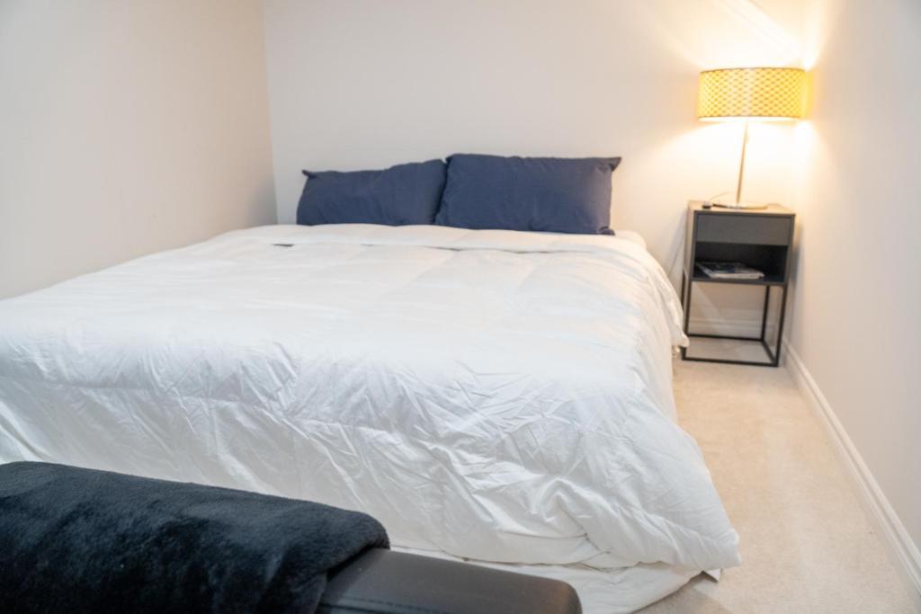 - une chambre avec un grand lit blanc et une chaise dans l'établissement Transpark Home, à Ottawa