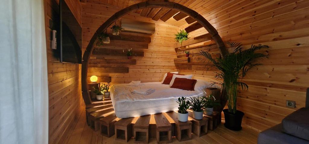 ein Schlafzimmer mit einem Bett in einem Holzzimmer in der Unterkunft Réteskert vendégház és apartman in Bélapátfalva