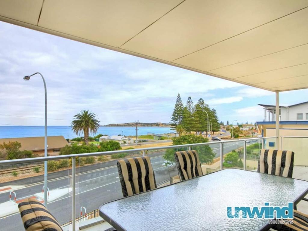 a table and chairs on a balcony with a view of the ocean at Block Escape No 5 - Penthouse Balcony Wi-fi in Victor Harbor