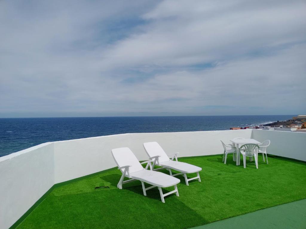 un gruppo di sedie e tavoli su un balcone con vista sull'oceano di Casa Fefa a Candelaria