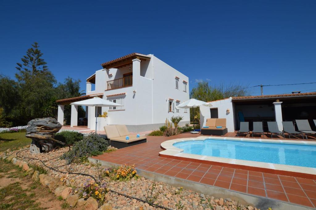 a villa with a swimming pool and a house at Cas Torres in Sant Jordi