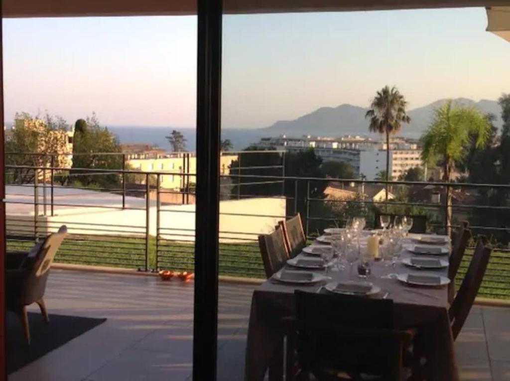- une table à manger avec vue sur un balcon dans l'établissement B002 - Superbe appartement avec Vue Mer et Piscine, à Cannes