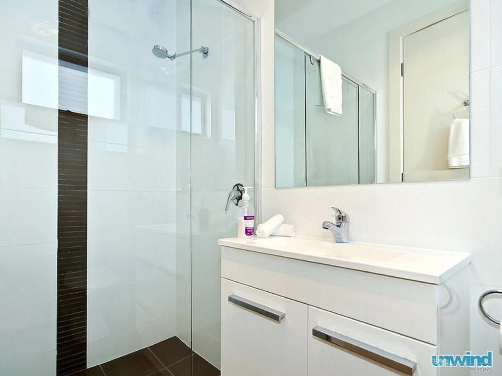 a white bathroom with a sink and a shower at The Block Escape - Ocean Views No 6 in Victor Harbor