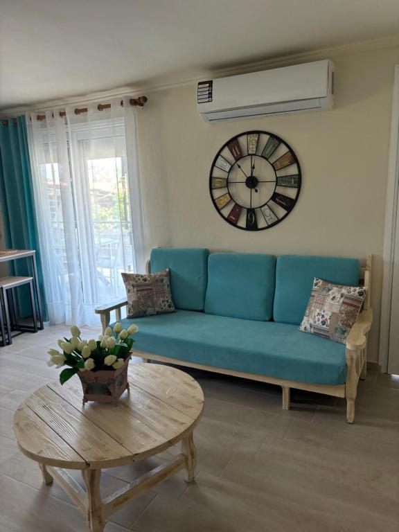 a living room with a blue couch and a clock at Άνεμος Home in Elaiokhórion