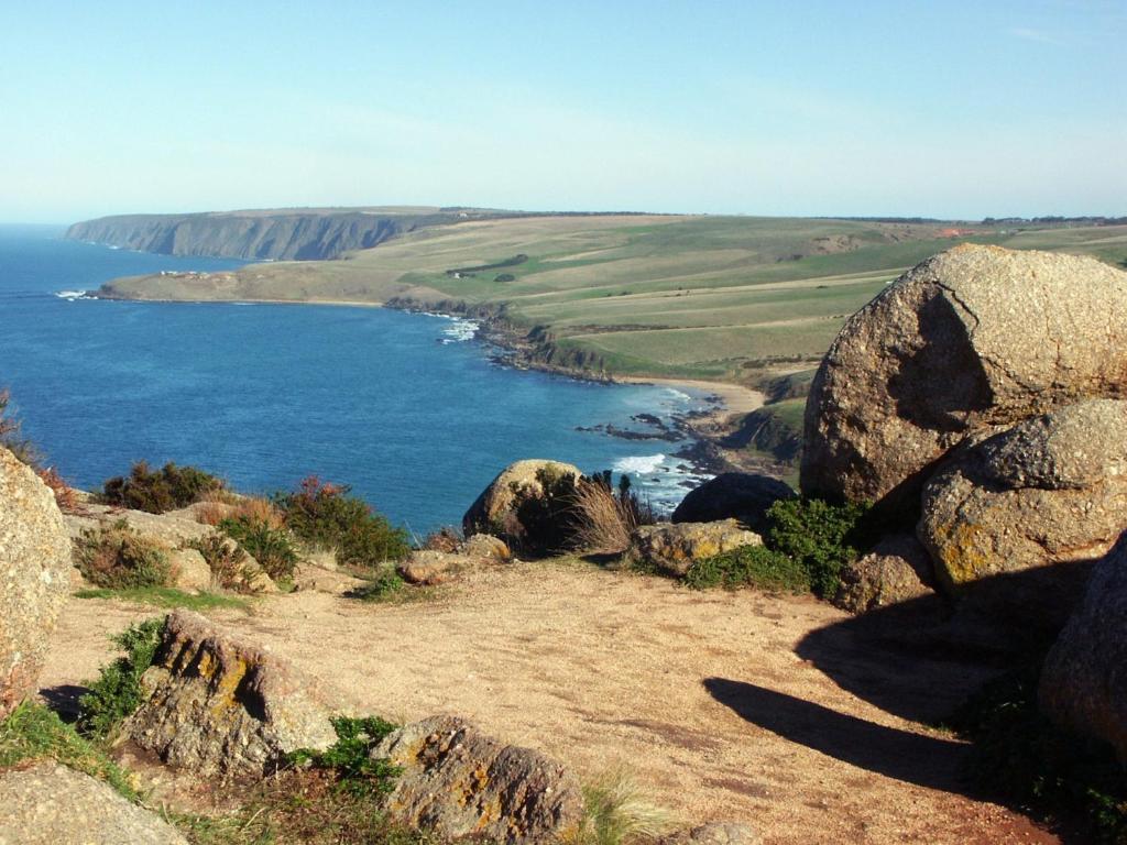 a view of the ocean from a hill with rocks at The Block Escape - Ocean Views No 6 in Victor Harbor