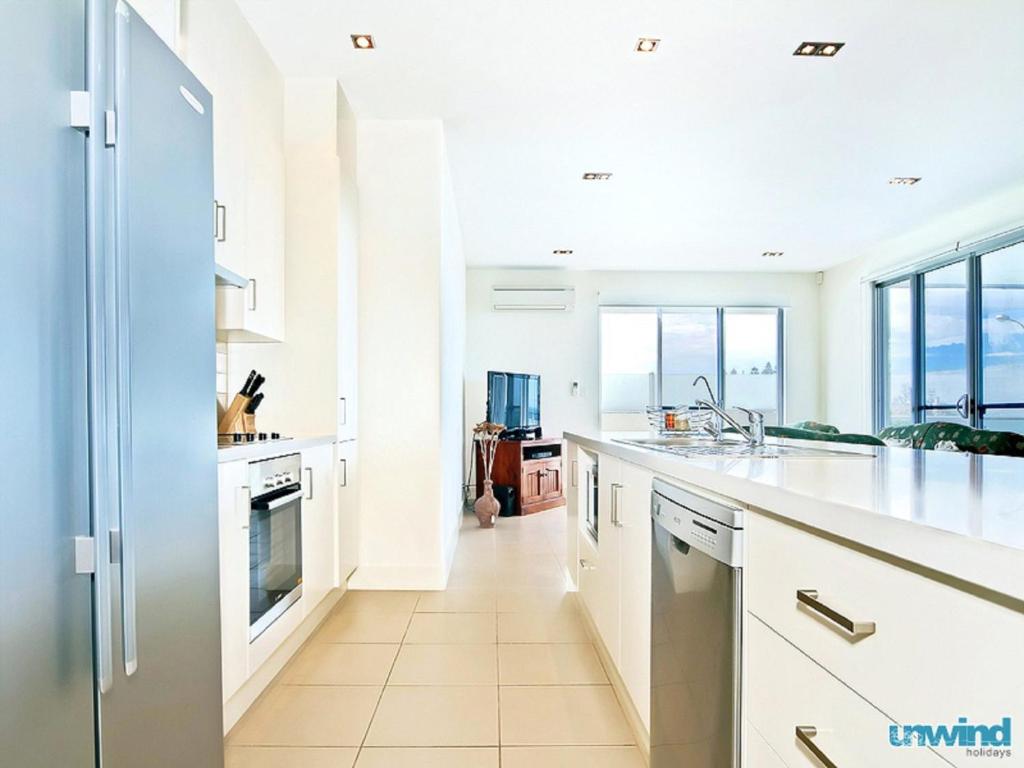 a kitchen with white cabinets and white appliances at The Block Escape - Ocean Views No 6 in Victor Harbor
