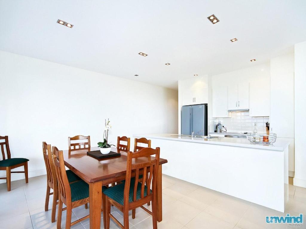 a kitchen and dining room with a wooden table and chairs at The Block Escape - Ocean Views No 6 in Victor Harbor