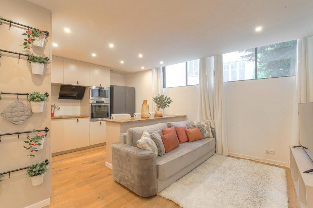 un salon avec un canapé et une cuisine dans l'établissement Cosy et Chaleureux wifi très haut débit, à Lyon