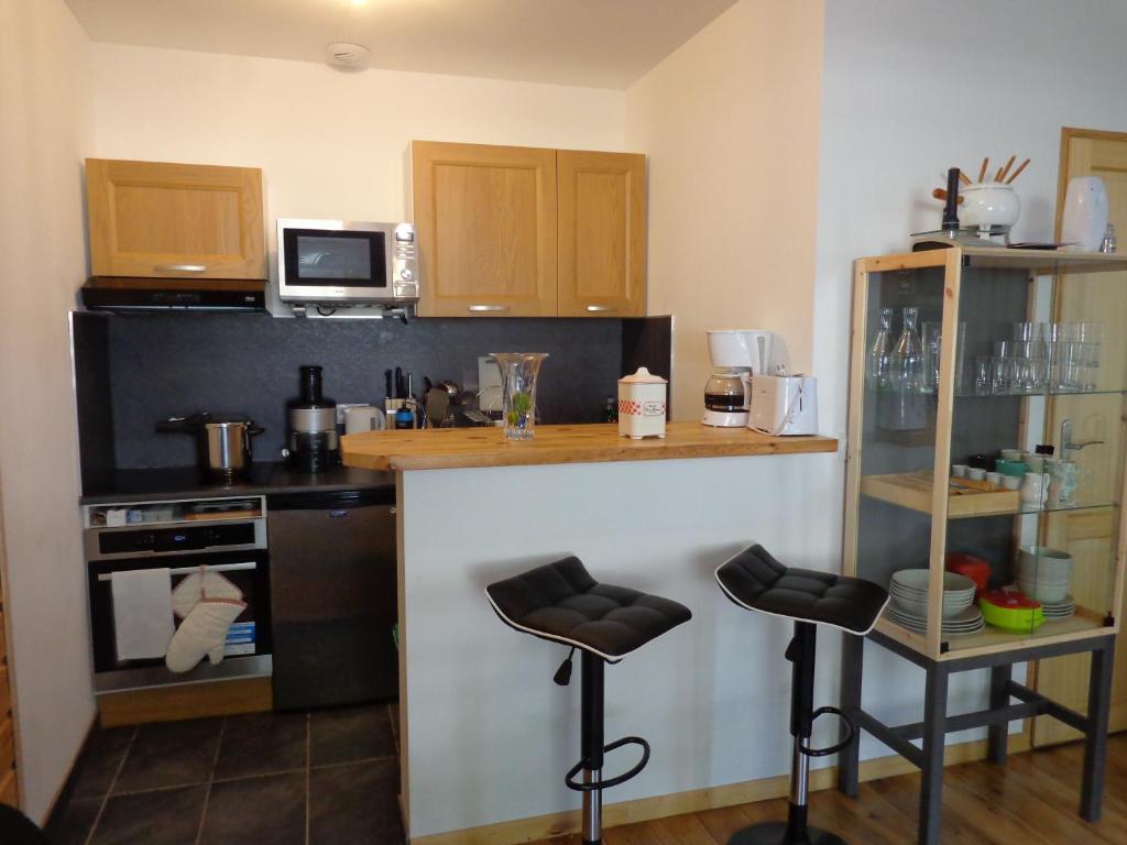 a kitchen with a counter and two bar stools at Appartement n° 32 in Barèges