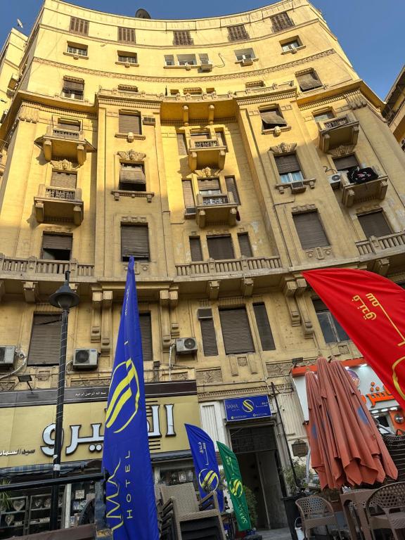 un edificio amarillo con banderas delante en Sama hotel en El Cairo