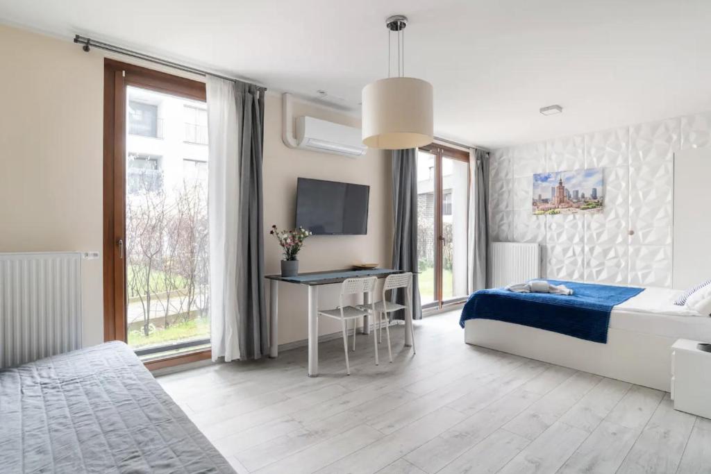ワルシャワにあるMOKO Apartment IIの白いベッドルーム(ベッド1台、デスク付)