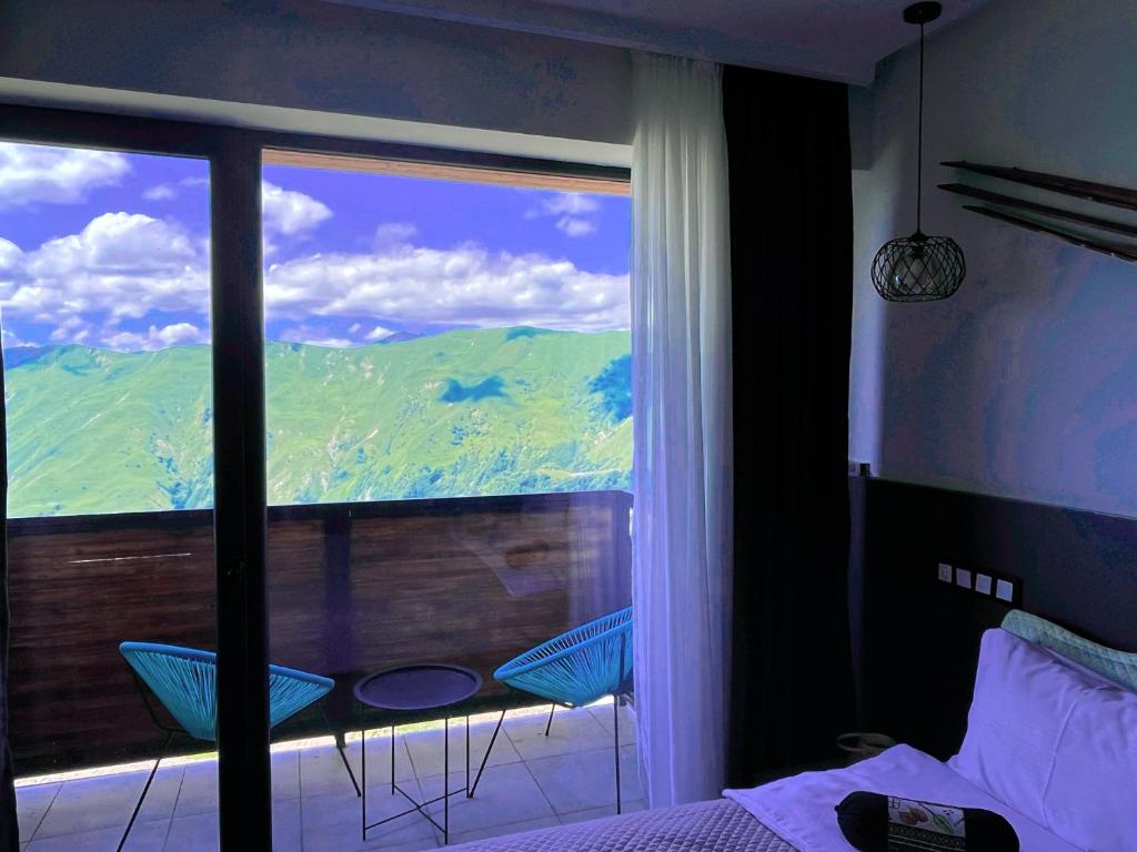 a bedroom with a view of a mountain from a window at Luxury hotel room with amazing views in Gudauri