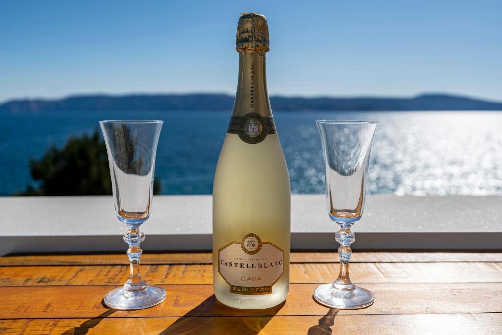 a bottle of champagne and two glasses on a table at MIMOZA2 in Novi Vinodolski