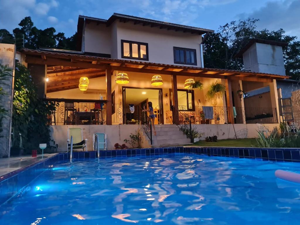 una casa con piscina frente a una casa en Casa Bonita - Aconchegante para se divertir e descansar, en Pirenópolis
