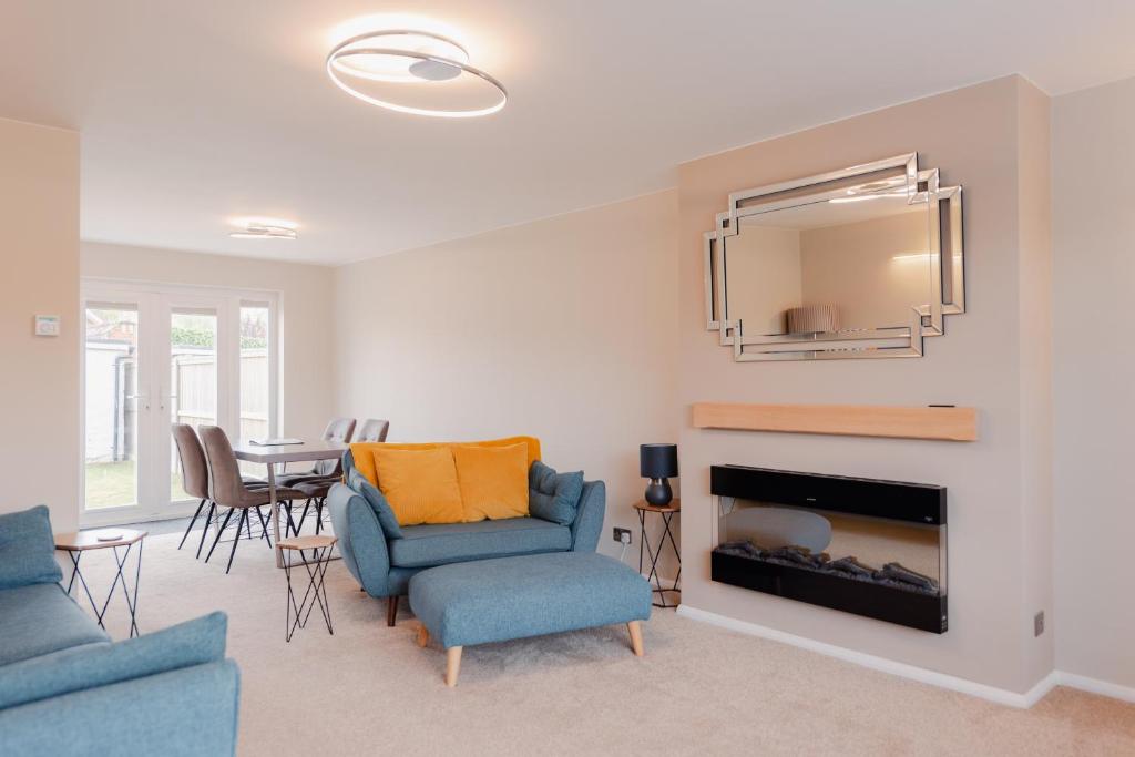 a living room with two blue chairs and a fireplace at Luxury Recently Renovated 3 Bedroom home in Sandwich Kent in Sandwich