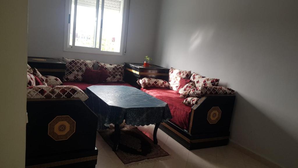 ein Wohnzimmer mit einem Sofa und einem Tisch in der Unterkunft Mouad house in Martil