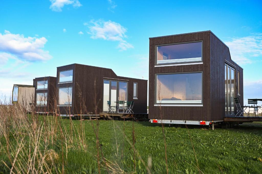 a row of modular homes sitting in a field at Tiny House Nature 16 Zur Meerseite - Green Tiny Village Harlesiel in Carolinensiel