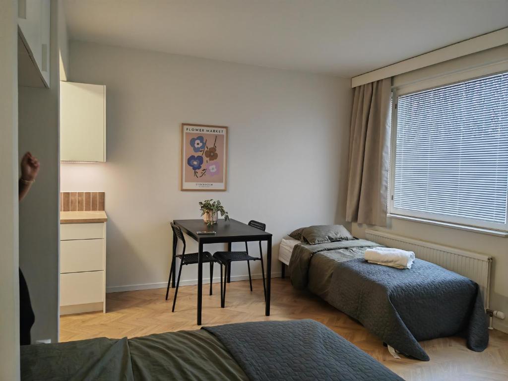 1 dormitorio con 2 camas, mesa y ventana en New central home, en Kuusamo