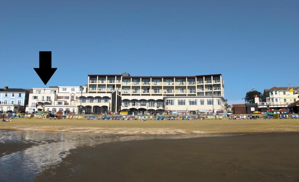 a large building on the beach with a building at Bay View - Seafront, Sandown --- Car Ferry Optional Extra 92 pounds Return from Southampton in Sandown