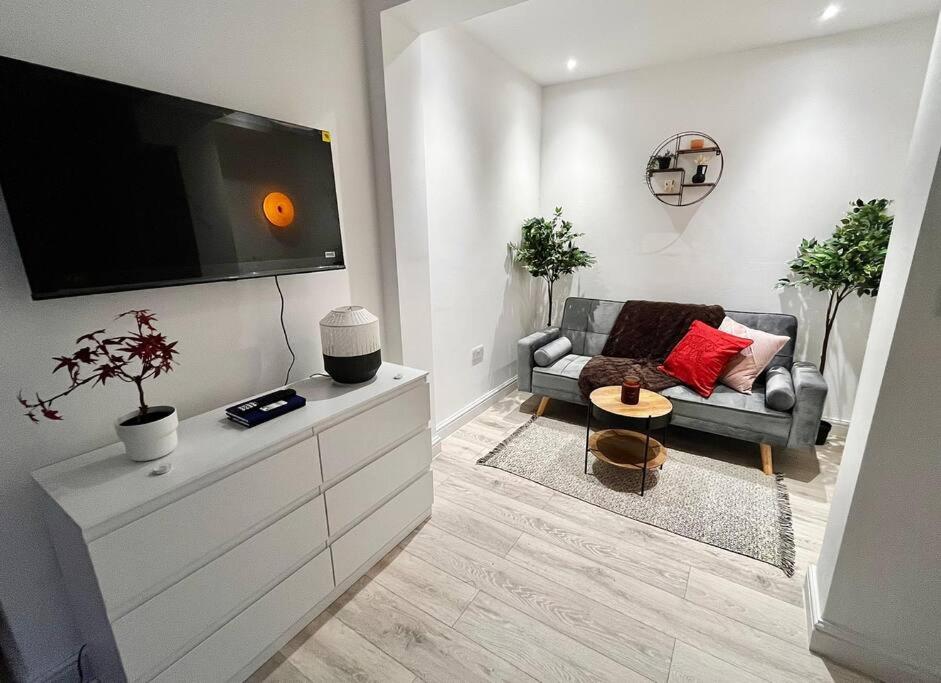 a living room with a couch and a flat screen tv at Modern Boutique Apartment Great Location in Golders Green