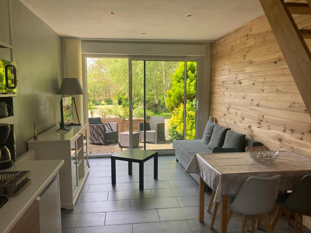 una cucina e un soggiorno con tavolo e divano di Gîte de Kermoal-location de vacances a Poullan-sur-Mer
