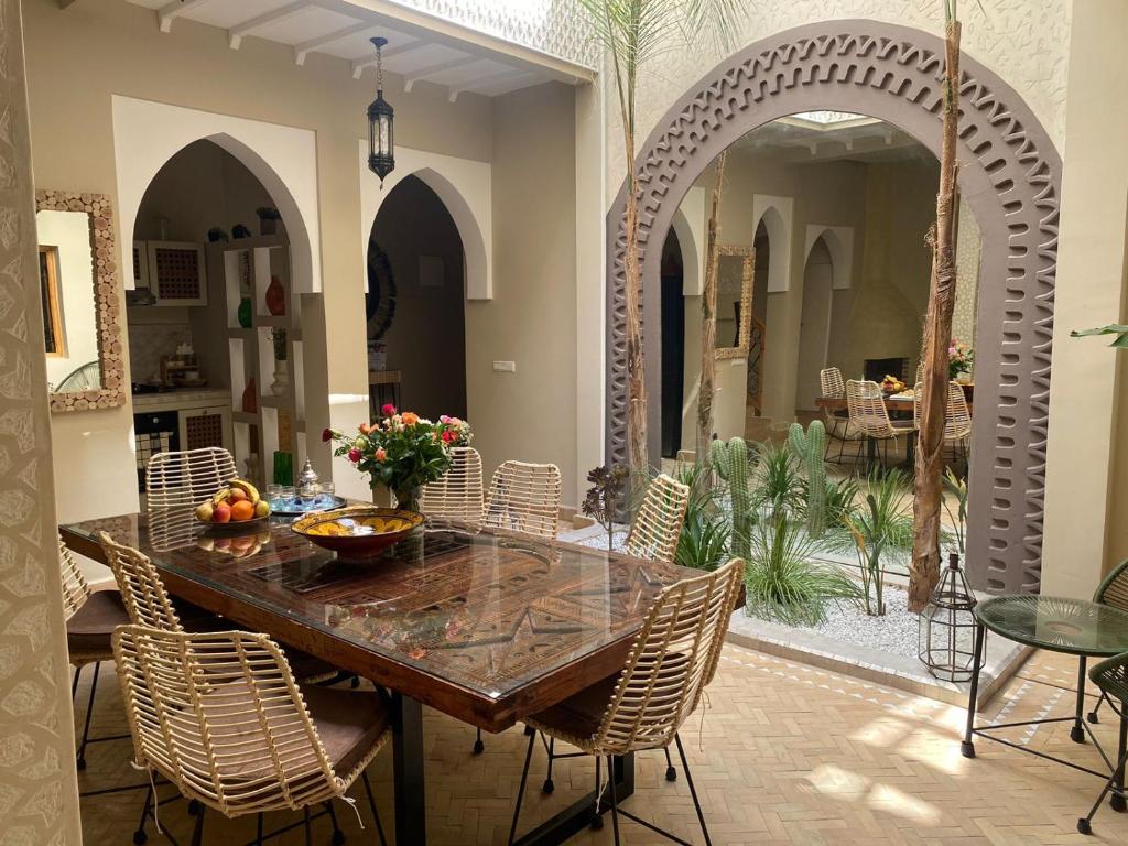uma sala de jantar com uma mesa de madeira e cadeiras em Magnifique Riad Privatif Kasbah em Marrakech