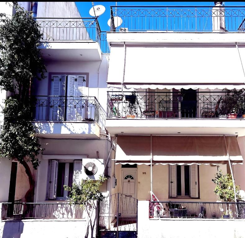 a tall white building with a porch and balcony at Mina's Veranda 90 sqm in Patra