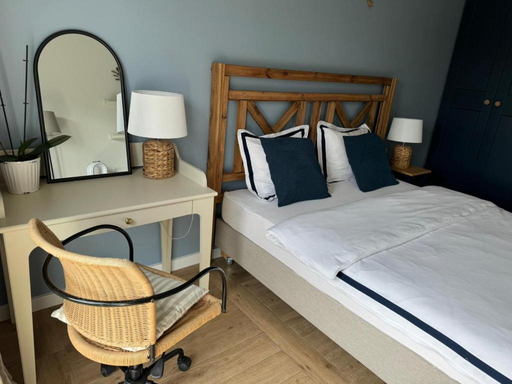sypialnia z łóżkiem z krzesłem i lustrem w obiekcie Apartament No 11 - HOME APART w Ostródzie