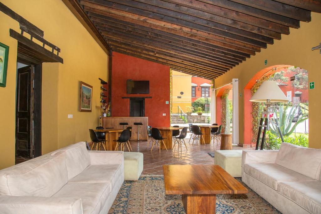 uma sala de estar com um sofá e uma mesa em Hotel Hacienda San Martin em Toluca