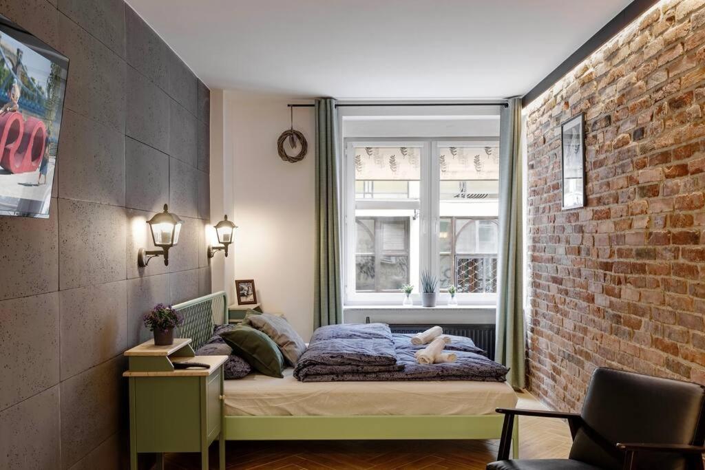 1 dormitorio con cama y pared de ladrillo en Jan's Urban Retreat, en Wroclaw