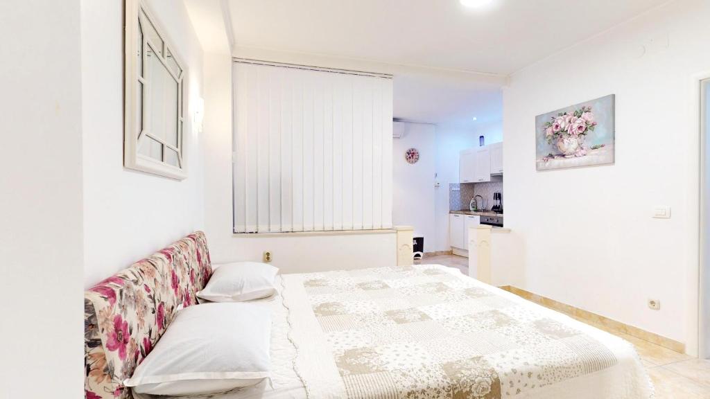 una camera bianca con un letto e una finestra di Apartments by the beach a Duće