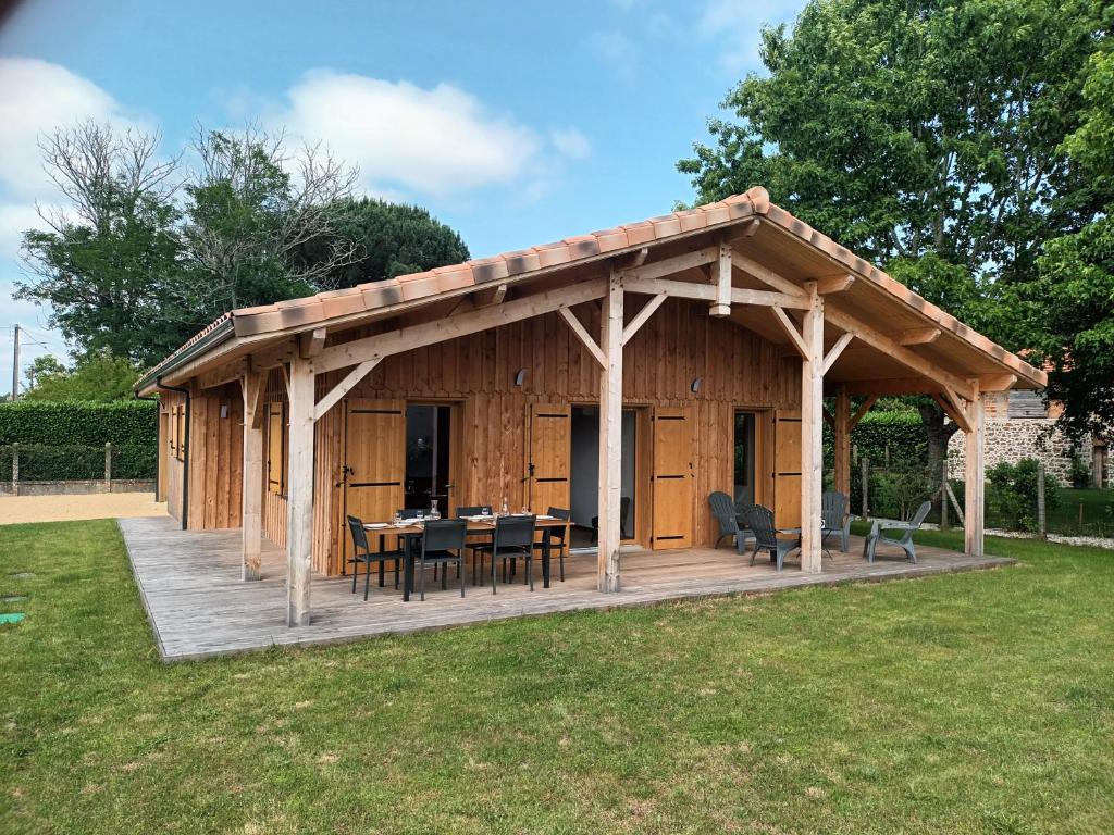 - un pavillon en bois avec une table et des chaises sur une terrasse dans l'établissement Jolie maison landaise tout confort, à Lugos