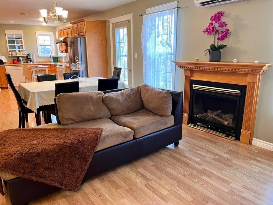 uma sala de estar com um sofá e uma lareira em Just Like Home em Charlottetown