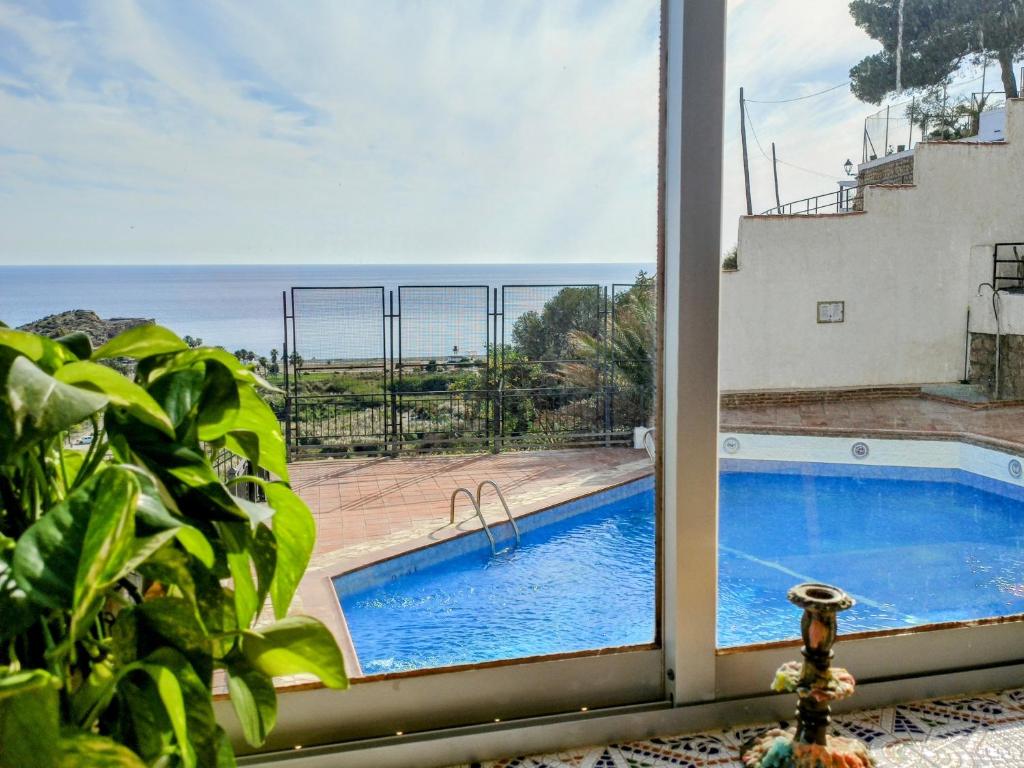 een raam met uitzicht op een zwembad bij Apartamento Bella Vista in Salobreña
