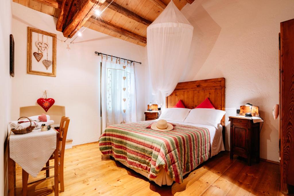 Agriturismo Le Noci في Tarzo: غرفة نوم بسرير وطاولة في غرفة