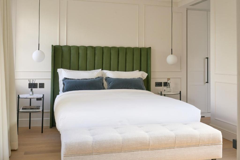 a bedroom with a large bed with a green headboard at The Store in Oxford