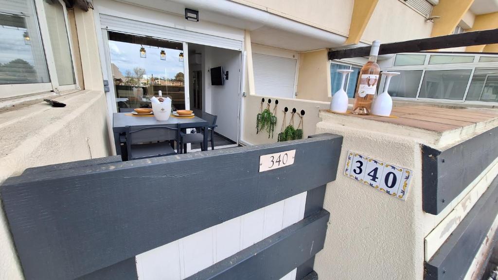 - une terrasse couverte à l'avant d'une maison avec une table dans l'établissement CapNat 340 Pas Seulement Desire, au Cap d'Agde