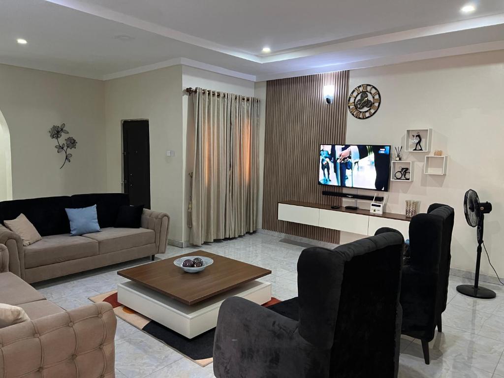 a living room with a couch and a tv at Well furnished and very spacious apartment in Wuye in Abuja