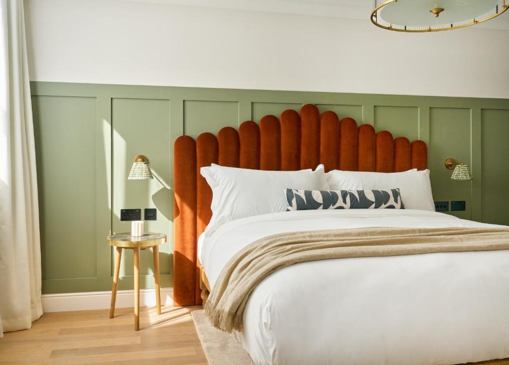 a bedroom with a large bed with a large orange headboard at The Store in Oxford