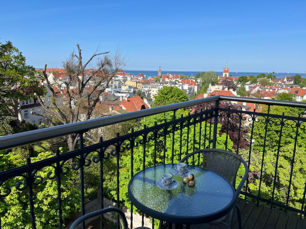 a table on a balcony with a view of a city at Panorama Apartament Sopot in Sopot