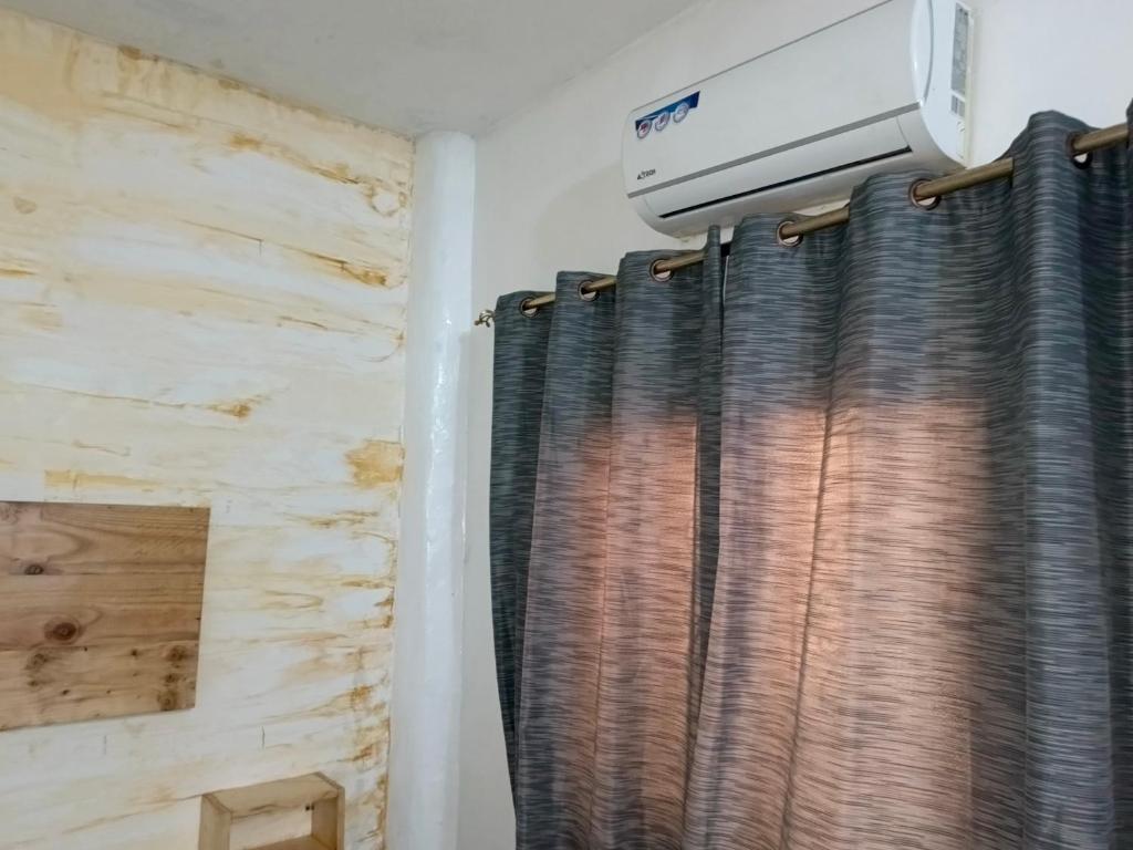 a room with a curtain and a air conditioner at Studio meublé sur la vdn liberté 6 extension in Dakar